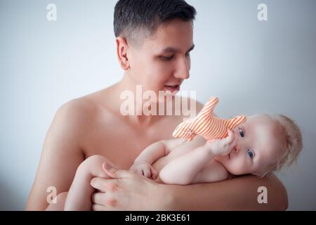 Père avec son jeune bébé de câliner et l'embrasser sur la joue. La paternité, l'amour. Banque D'Images