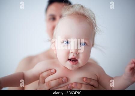 Père avec son jeune bébé de câliner et l'embrasser sur la joue. La paternité, l'amour. Banque D'Images