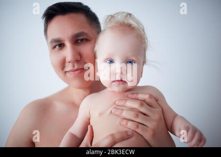 Père avec son jeune bébé de câliner et l'embrasser sur la joue. La paternité, l'amour. Banque D'Images