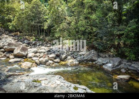 Les gens assis sur les rochers dans la rivière dans la gorge de Mossman dans le parc national de Daintree Banque D'Images