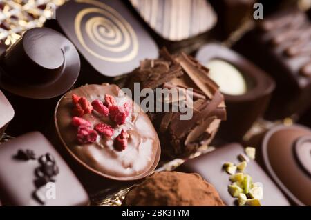 Truffes au chocolat noir et au lait de luxe. Assortiment de délicieux pralines au chocolat faites à la main à la suite. Arrière-plan plein format. Prise de vue en studio. Gros plan. Banque D'Images