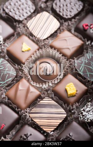 Truffes au chocolat noir et au lait de luxe. Assortiment de délicieux pralines au chocolat faites à la main à la suite. Arrière-plan plein format. Prise de vue en studio. Gros plan. Banque D'Images