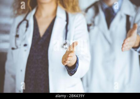 Deux médecins debout et offrant une main d'aide pour secouer la main ou sauver la vie. Aide médicale, lutte contre l'infection virale et le concept de médecine Banque D'Images