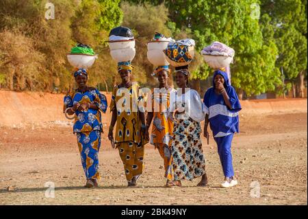 Les femmes de la région marchant et portant la lessive sur leur tête sur le rivage de la rivière Bani à Mopti au Mali, en Afrique de l'Ouest. Banque D'Images