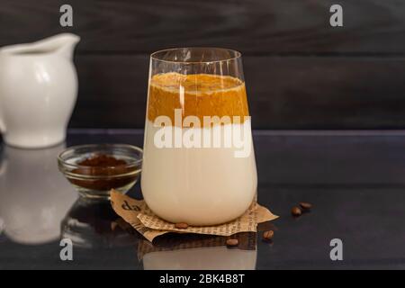 Le café Dalgona est une boisson froide et tendance de la Corée. Café savoureux et aromatique avec lait et sucre dans un verre sur fond noir. Espace de copie Banque D'Images