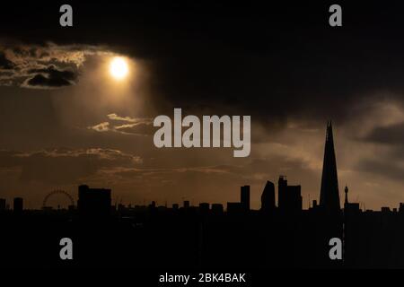 Londres, Royaume-Uni. 1 mai 2020. Météo britannique : un soleil nocturne spectaculaire traverse des nuages sombres après un bref orage. Le bâtiment de gratte-ciel Shard et la roue ferris London Eye sont en vue. Crédit: Guy Corbishley/Alay Live News Banque D'Images