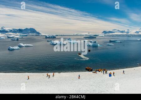 Touristes sur l'île de Cuverville dans la région de la péninsule Antarctique visitant la colonie de pingouins de Gentoo (Pygoscelis papouasie) Banque D'Images