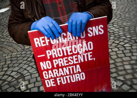 Un manifestant portant un placarde tout en portant des gants par mesure de précaution contre le covid 19, lors de la manifestation. Le syndicat des travailleurs a célébré la fête du travail par une protestation silencieuse à Porto et a suivi la plupart des mesures de verrouillage du coronavirus. Ils exigent l'attention sur les violations des droits des travailleurs qui ont été faites avec l'excuse de la pandémie. Banque D'Images