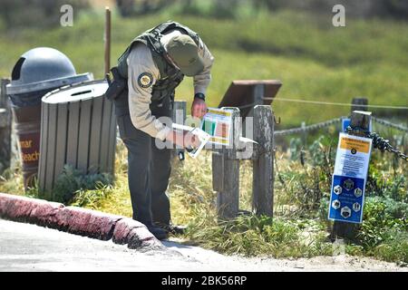 Pacific Grove, Californie, États-Unis. 1 mai 2020. California State Parks Peace Officer affichant des panneaux pour clarifier le.règles de loisirs pour Asilomar State Beach pendant la COVID-19 Shelter en place Commander crédit: Rory Merry/ZUMA Wire/Alay Live News Banque D'Images