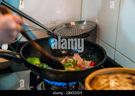 Chef cuisinier Ding l'enseignement d'un groupe de touristes à Shanghai comment faire cuire le bœuf avec les poivrons. Banque D'Images