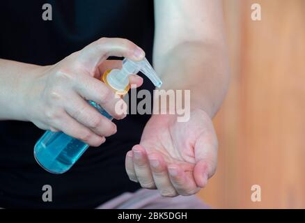 Femme asiatique qui a pressé le gel d'alcool de la bouteille et le gel désinfectant de lavage pour se laver les mains à nettoyer et à éliminer les bactéries, la pollution de l'air sale et le virus pour p Banque D'Images