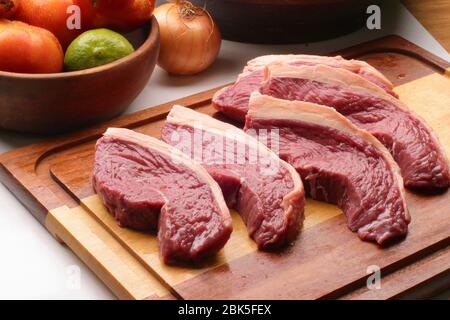 steaks bruts en tranches avec couverture grasse sur base en bois. Banque D'Images