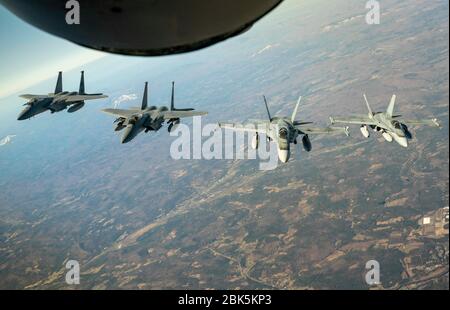 Avions de combat F-15 de la Force aérienne américaine à partir de la 104ème Escadre de chasseurs de la Garde nationale de l'Air du Massachusetts et des avions de chasse de la Force aérienne royale du Canada CF-18 de la 3e Escadre, Bagotville, Le Québec se joint derrière une garde nationale de l'air du Maine KC-135 Stratotanker de la 101ème Escadre de ravitaillement en carburant aérien lors d'une manifestation transfrontalière continentale de la région continentale de l'Amérique du Nord du Commandement de la défense aérospatiale et de la région canadienne du NORAD, le 23 avril 2020. L'équipage de conduite et les membres de la Garde nationale aérienne et de la Force aérienne royale du Canada ont pratiqué des compétences d'interception tactique dans un exercice de défense aérienne conçu pour renforcer l'interopérabilité dans l'ensemble de la Banque D'Images