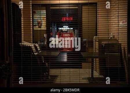 Los Angeles, CA/USA - 20 avril 2020: Un panneau ouvert à l'entrée d'un restaurant derrière une porte en acier la fermant pendant la quarantaine du coronavirus Banque D'Images