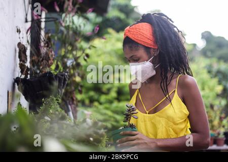 La jeune femme prend soin du jardin pendant le verrouillage du coronavirus en Colombie Banque D'Images