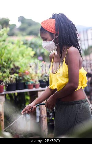 La jeune femme prend soin du jardin pendant le verrouillage du coronavirus en Colombie Banque D'Images