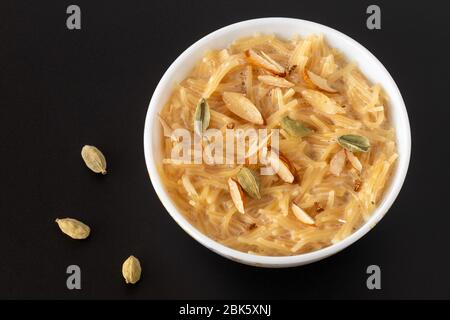 Dessert vermicelles plat sucré populaires, savoir un kheer fabriqués avec du lait et garnir de fruits secs isolé sur fond gris noir, servi dans un bol. Séle Banque D'Images