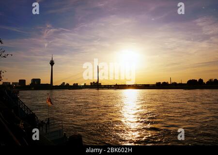 Vue panoramique sur la ville avec coucher de soleil romantique sur le Rhin à Düsseldorf avec les deux sites du Rhin tour et Rheinkniebrucke. Banque D'Images