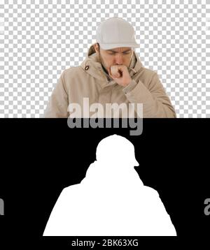 Homme en tenue d'hiver marchant et toussant, Alpha Channel Banque D'Images