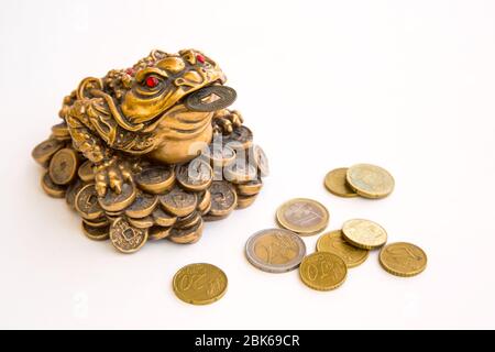 Grenouille monétaire feng shui symbole de prospérité et pièces en euros isolées sur fond blanc Banque D'Images