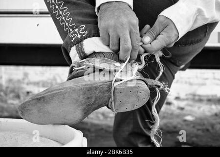 Le cow-boy mexicain attachant ses épeurs avec une corde. Banque D'Images