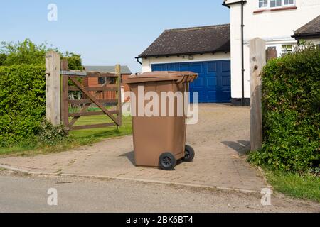 Une maison à l'orne à roue marron simple prête à être vidée par des collecteurs de déchets. Beaucoup Hadham, Hertfordshire. ROYAUME-UNI Banque D'Images