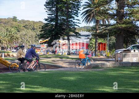 Trois personnes âgées d'âge moyen hommes et femmes qui font du vélo dans un parc pour faire de l'exercice pendant la pandémie de covid 19 à Sydney, Australie Banque D'Images