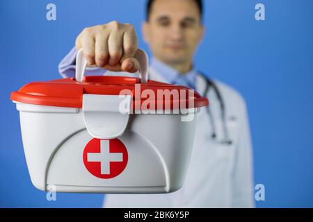 beau cheveux sombre 40 médecin homme contient rouge croix kit d'aide médicale Banque D'Images