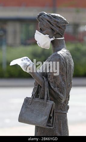 Une statue de l'artiste Ross Wilson, la fille mère sœur, célébrant l'identité et la culture féminines, à Sandy Row Belfast est ornée d'un masque et de gants jetables, tandis que le Royaume-Uni se dirige vers une septième semaine en position de verrouillage pour essayer de limiter la propagation du coronavirus. Banque D'Images