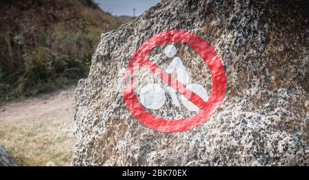 panneau interdisant aux cyclistes peints sur une roche près de la mer Banque D'Images