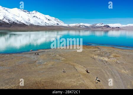 Lhasa. 30 avril 2020. La photo aérienne prise le 30 avril 2020 montre des personnes qui équitation des chevaux par Tangqung Co Lake à Nagqu, dans la région autonome du Tibet du sud-ouest de la Chine. Crédit: Hou Jie/Xinhua/Alay Live News Banque D'Images