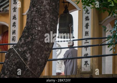 Les Monks bouddhistes de Hanoi, Vietnam sonnent la cloche pour la prière du soir Banque D'Images