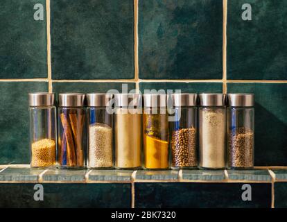 Épices dans des pots en verre dans la cuisine. Un ensemble d'épices (curcuma, coriandre, poivre, cannelle, moutarde) pour la cuisine maison. Banque D'Images