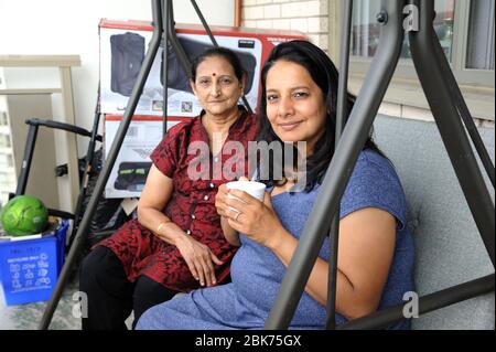 Mumbai, Maharashtra, Inde- Asie, août 10, 2018 - bonne mère et fille indiennes qui s'amusent à boire du thé ensemble sur l'oscillation Banque D'Images