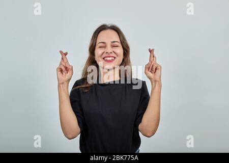 Happy Girl Smiles pour bonne chance, garde ses doigts croisés Banque D'Images