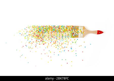 Un pinceau dessine une ligne droite avec des confettis colorés de vacances. Fond blanc. Banque D'Images