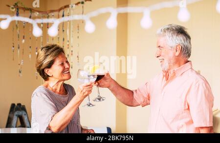 Un couple caucasien de personnes âgées et de personnes âgées heureux célèbrent avec une tasse de vin - des gens qui ont des boissons de célébrationth amusantes - retraite de joie de vivre - fin Banque D'Images