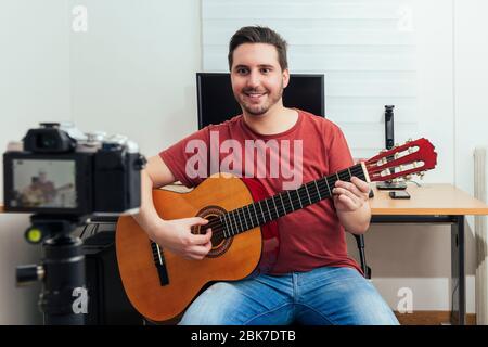 Blogger enregistrant la leçon de guitare de son studio à la maison. Apprentissage du concept en ligne. Banque D'Images