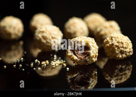 Dessert composé de boules maison saupoudrées de noisettes farcies au chocolat Banque D'Images