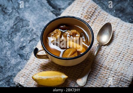 Compote maison avec mélange de fruits secs de dattes et figues avec citron dans une tasse Banque D'Images