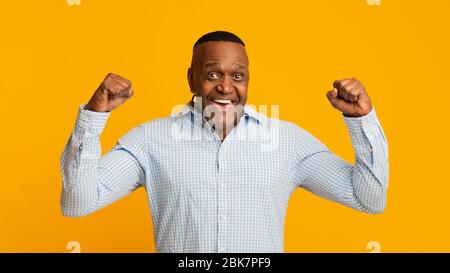 Homme africain fort d'âge moyen montrant des biceps Banque D'Images