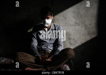 Jisr Al Shughur, Syrie. 02 mai 2020. Un homme porte un masque facial lorsqu'il est assis dans un centre d'isolement sanitaire qui a été établi aux frontières syro-turque afin de placer les personnes venant de Turquie à Idlib comme mesure préventive contre la propagation de la maladie du coronavirus (COVID-19). Le centre est supervisé par une équipe médicale formée à toutes les mesures à prendre pour traiter les expatriés puisque le centre a reçu plus de 600 personnes jusqu'à présent et la période d'isolement est de 15 jours. Crédit: Anas Alkharboutli/dpa/Alay Live News Banque D'Images