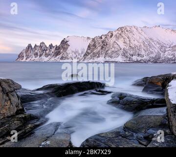 La plage rocheuse et les vagues gelées dans la piscine sur Ersfjord. Île de Senja dans la région des Troms, dans le nord de la Norvège. Prise de vue en cas d'exposition prolongée Banque D'Images