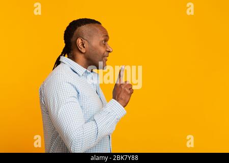 Homme africain mûr ayant une idée, pointant vers le haut Banque D'Images