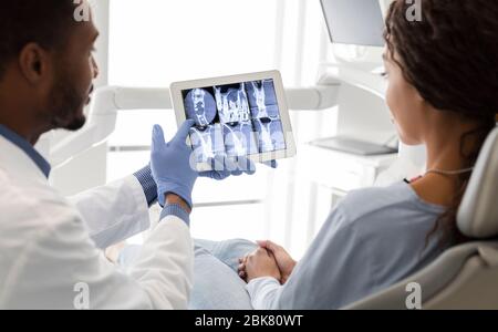 Dentiste et patient regardant l'image de radiographie sur l'écran numérique Banque D'Images