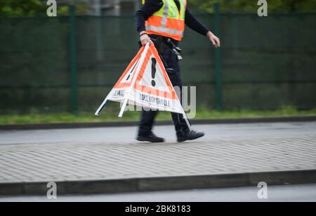 30 avril 2020, Hessen, Francfort-sur-le-Main: Un agent des douanes établit un triangle d'avertissement "contrôle des douanes". Le bureau de douane principal de Francfort effectue actuellement des contrôles de camions à l'aéroport. Photo: Andreas Arnold/dpa Banque D'Images