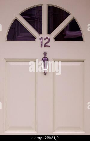 Maison numéro 12 sur une porte en bois vert clair avec des panneaux de verre disposés dans un demi-cercle ci-dessus Banque D'Images