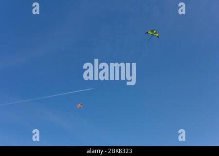 Rubans colorés et figurines en cerf-volant accrochés sur des poteaux et volantes sur fond bleu kite festival Banque D'Images