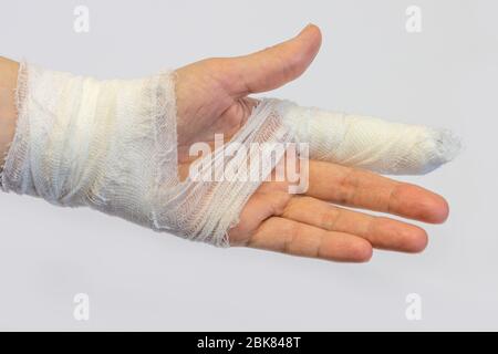 une main de femme blessée à gauche avec un doigt de pointeur bandé sur un fond blanc, montrant la partie intérieure de la paume Banque D'Images