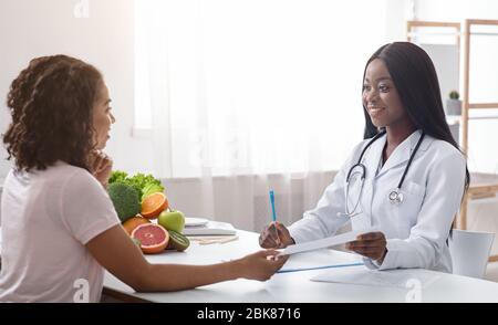 Une diététiste de joli médecin donnant un plan de traitement pour les femmes Banque D'Images